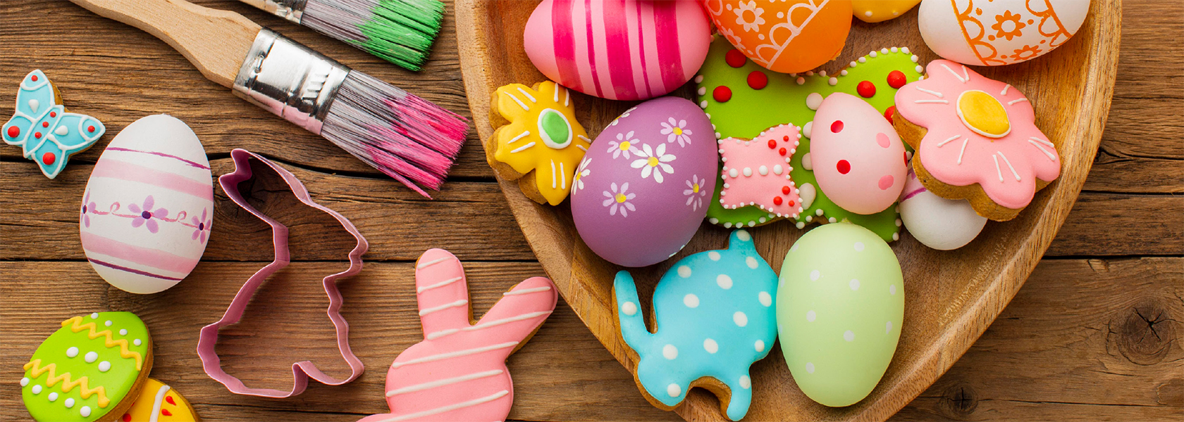 Kekse mit österlichen Motiven, Pinsel und andere Bastelmaterialien für Ostern